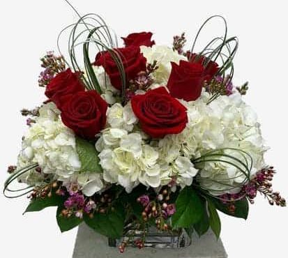 Beautiful red roses with white hydrangea and greenery in a lush bountiful displat