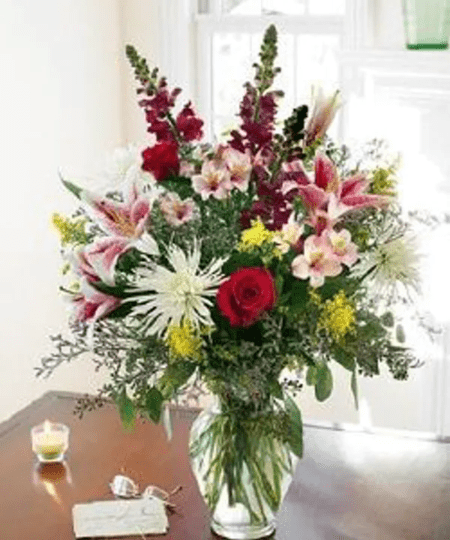 Express your caring wishes with our gracious bouquet. We can have a magnificent design created from fresh floral favorites such as roses, 'Stargazer' lilies, snapdragons, Fuji mums, alstroemeria, and fresh greens and present them in a classic glass vase.